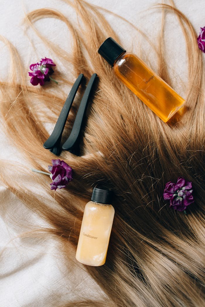 about-02 Aesthetic flatlay of hair care items and flowers against a soft background.